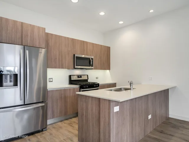 a kitchen with a refrigerator a microwave a sink and cabinets