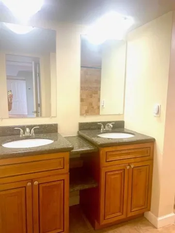a bathroom with a granite countertop sink a toilet and a mirror
