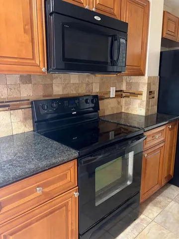 a kitchen with wooden cabinets and a stove top oven