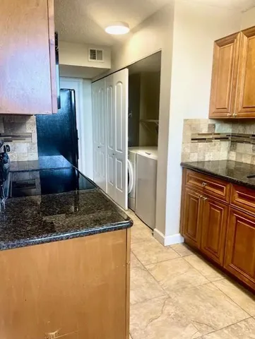 a kitchen with stainless steel appliances granite countertop a sink and a refrigerator