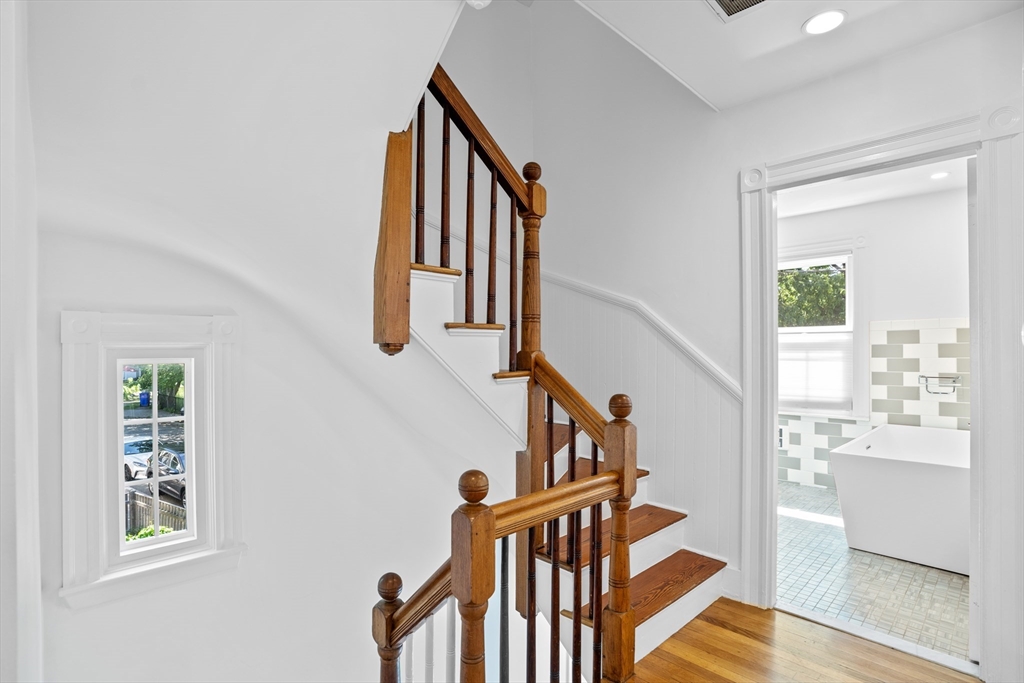 81 Franklin Street Brookline, MA 02445 - Photo 17 of 25 a view of staircase with lots of frames on wall and a window