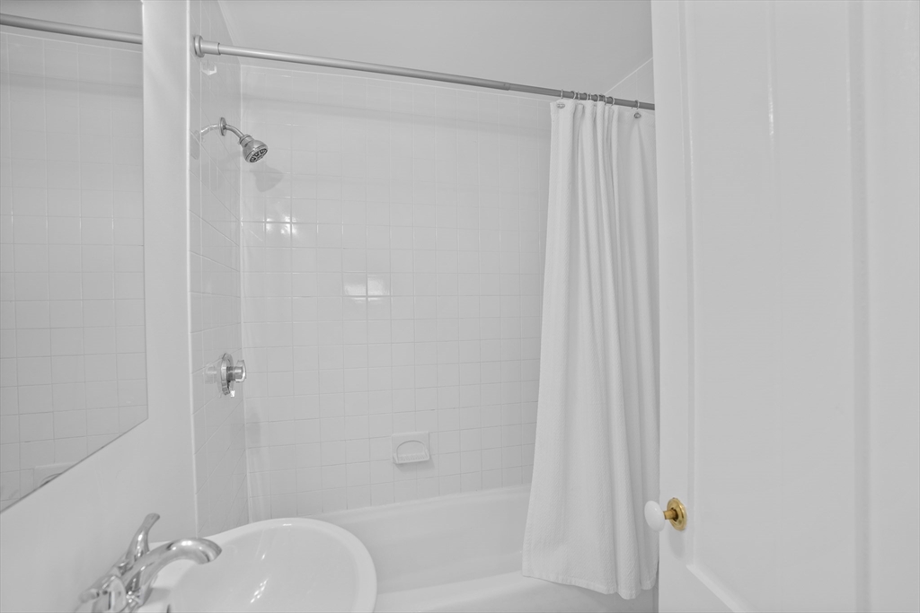 81 Franklin Street Brookline, MA 02445 - Photo 21 of 25 a bathroom with a shower curtain and a sink