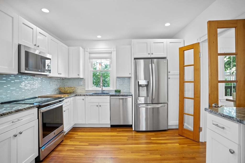 81 Franklin Street Brookline, MA 02445 - Photo 6 of 25 a kitchen with stainless steel appliances granite countertop a refrigerator a stove top oven a sink and dishwasher