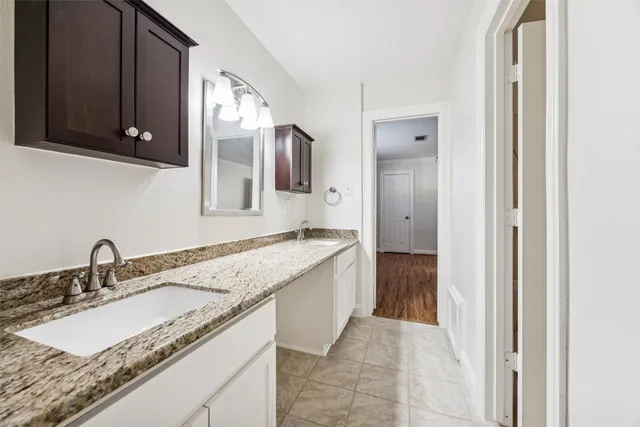 a bathroom with a granite countertop sink and a mirror