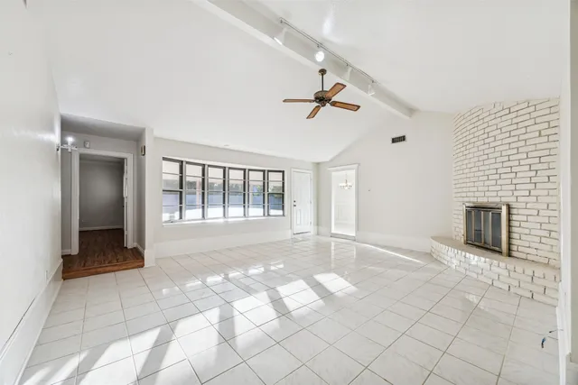a view of empty room with wooden floor and fireplace