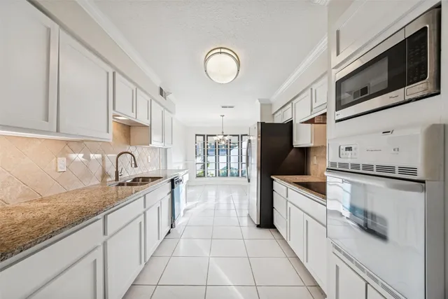 a large kitchen with stainless steel appliances granite countertop a stove sink and cabinets