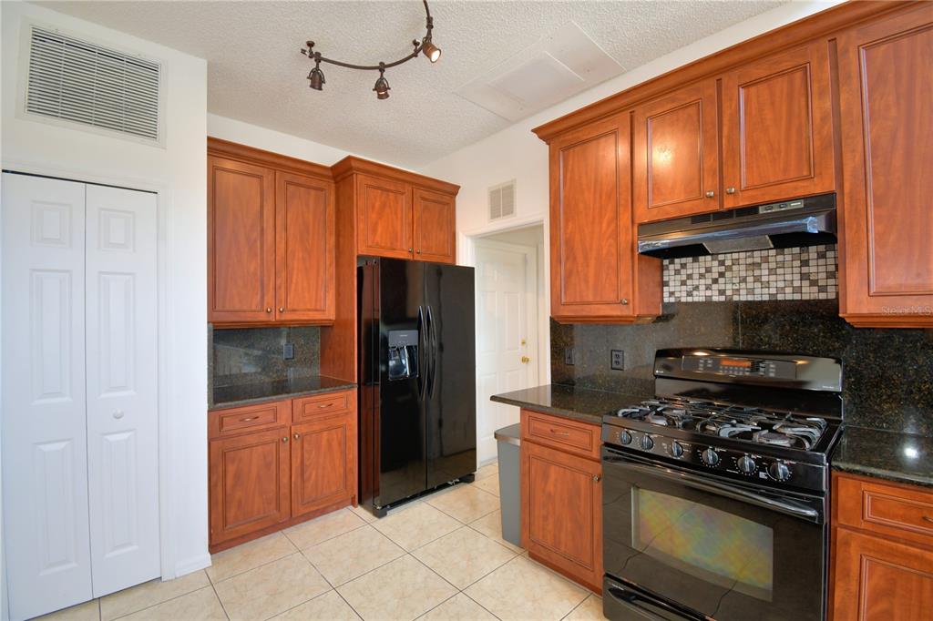 5368 Dahlia Reserve Drive Kissimmee, FL 34758 - Photo 20 of 83 a kitchen with stainless steel appliances granite countertop a stove refrigerator and cabinets
