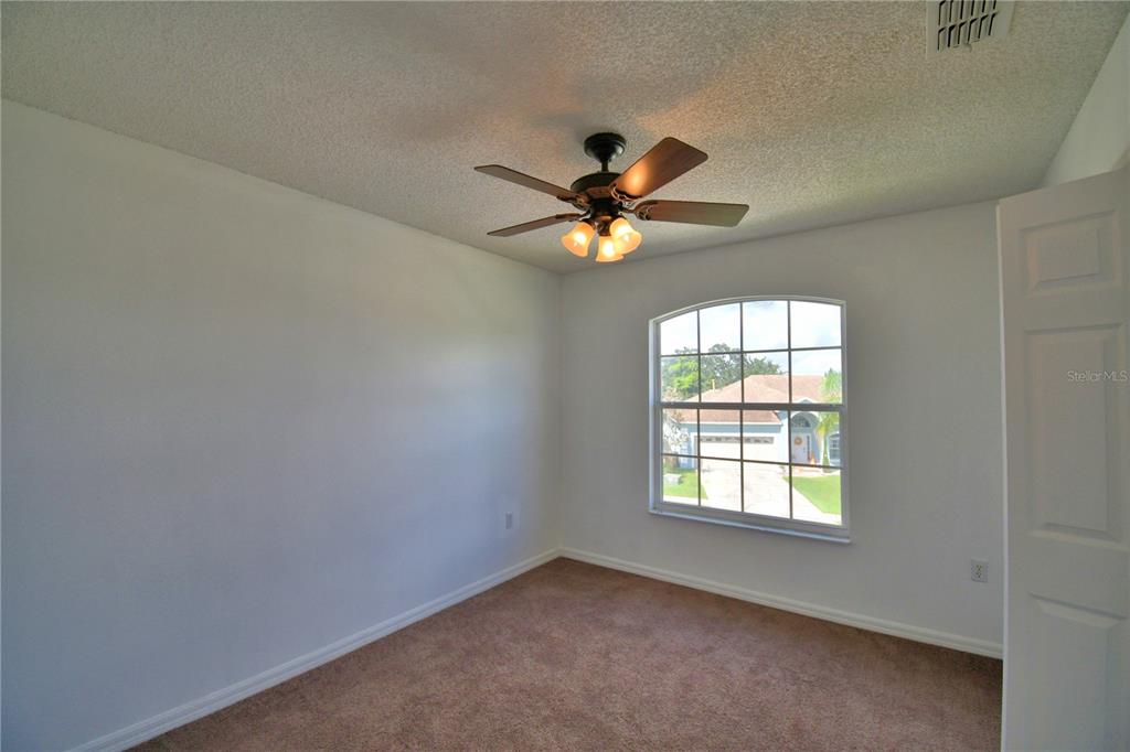 5368 Dahlia Reserve Drive Kissimmee, FL 34758 - Photo 45 of 83 an empty room with windows and chandelier fan