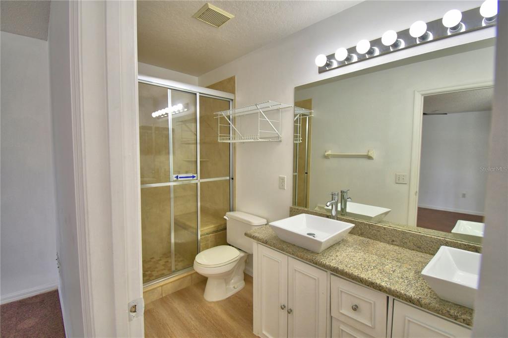 5368 Dahlia Reserve Drive Kissimmee, FL 34758 - Photo 63 of 83 a bathroom with a granite countertop sink a toilet and shower