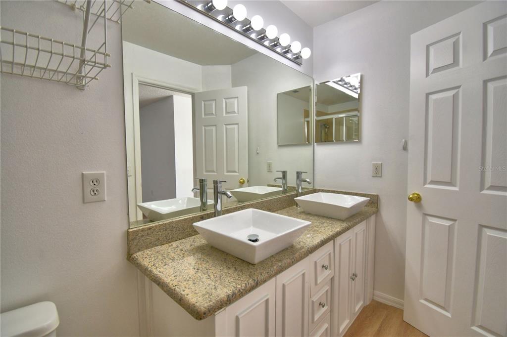 5368 Dahlia Reserve Drive Kissimmee, FL 34758 - Photo 65 of 83 a bathroom with a granite countertop sink a mirror and a toilet