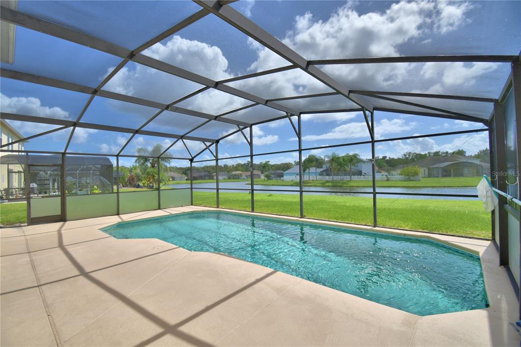 5368 Dahlia Reserve Drive Kissimmee, FL 34758 - Photo 69 of 83 a view of a backyard with table and chairs under an umbrella