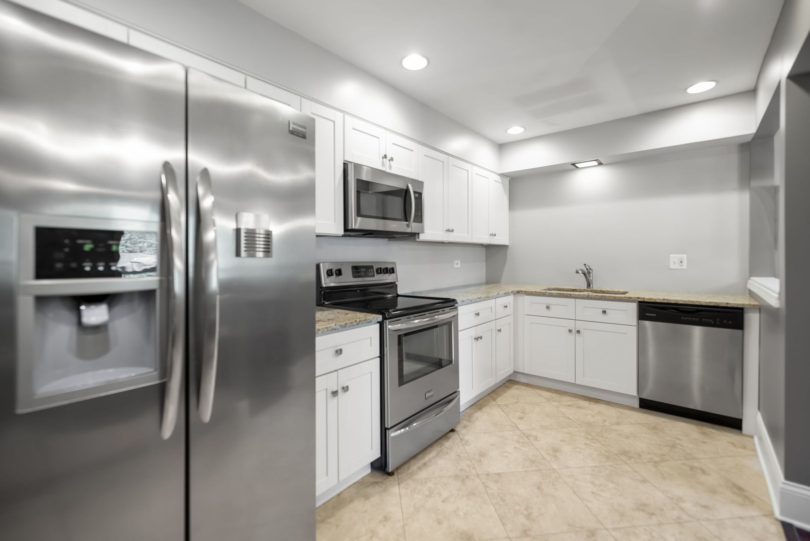 4133 Saratoga Avenue, Unit B220 Downers Grove, IL 60515 - Photo 5 of 18 a kitchen with stainless steel appliances granite countertop a refrigerator a stove and a sink