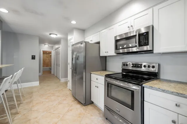 a kitchen with stainless steel appliances granite countertop a stove a microwave and a refrigerator