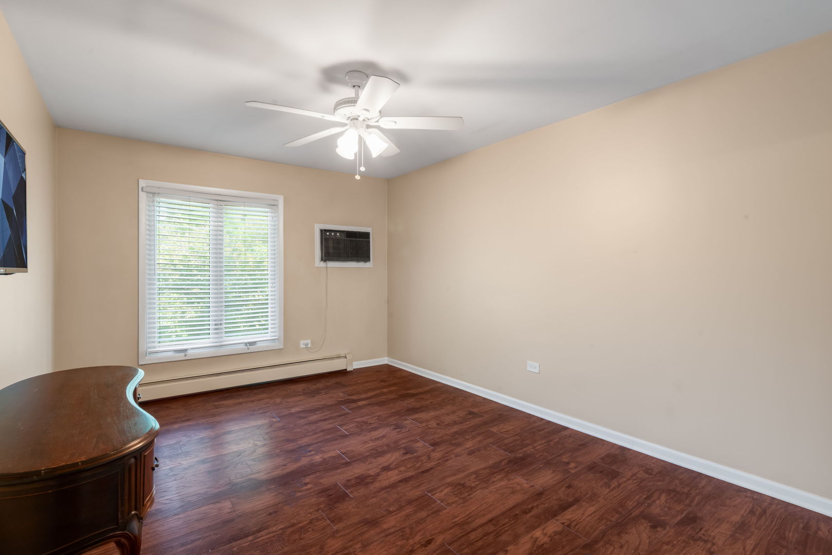 4133 Saratoga Avenue, Unit B220 Downers Grove, IL 60515 - Photo 8 of 18 a view of an empty room with wooden floor and a window