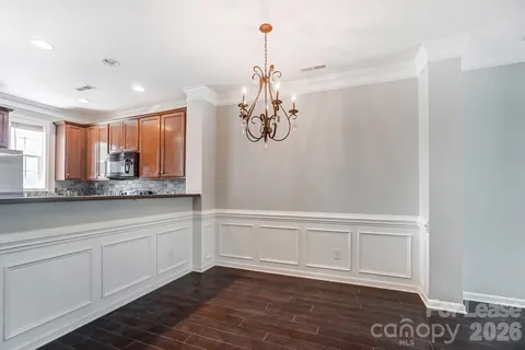 a kitchen with granite countertop white cabinets and window