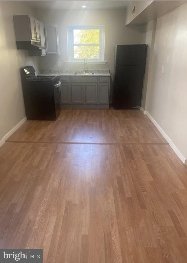 2219 Madison Street, Unit B Chester, PA 19013 - Photo 2 of 5 a kitchen with granite countertop a sink and a stove top oven