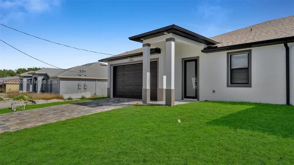 a front view of a house with a yard and garage