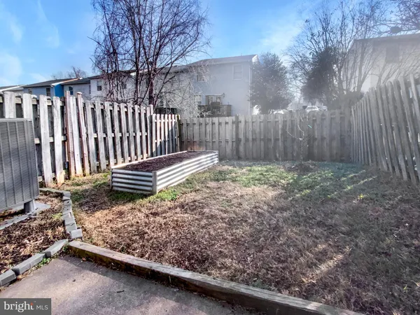 a view of backyard with wooden fence