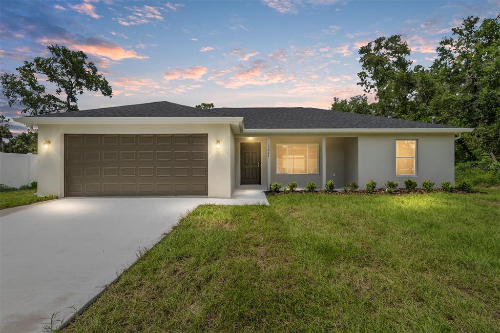 front view of a house with a yard and a garage