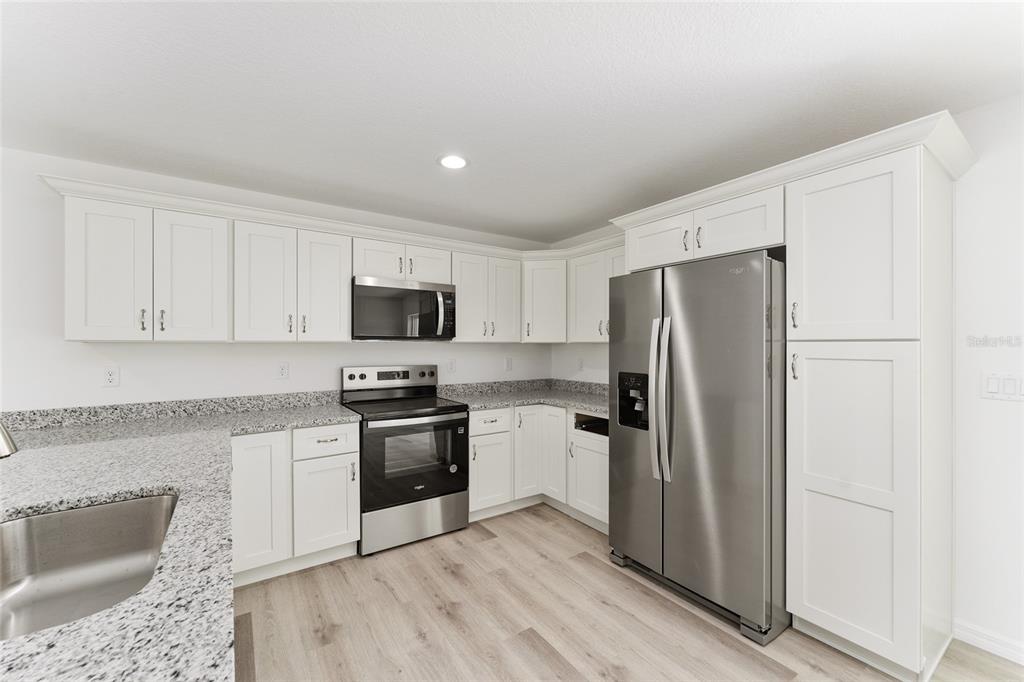 319 Fisher Road Ocklawaha, FL 32179 - Photo 16 of 48 a kitchen with stainless steel appliances granite countertop a refrigerator stove and sink