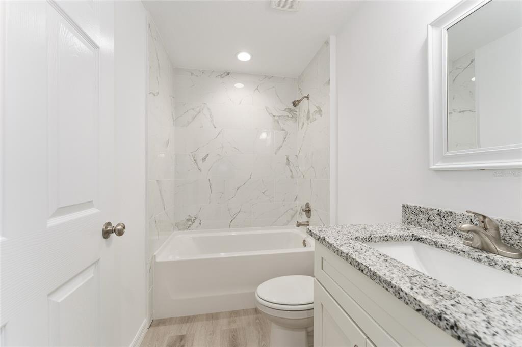319 Fisher Road Ocklawaha, FL 32179 - Photo 26 of 48 a bathroom with a granite countertop sink a toilet and bathtub