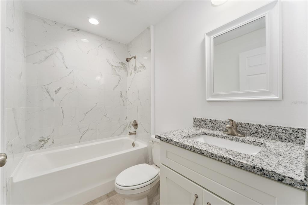 319 Fisher Road Ocklawaha, FL 32179 - Photo 27 of 48 a bathroom with a granite countertop sink a toilet and bathtub