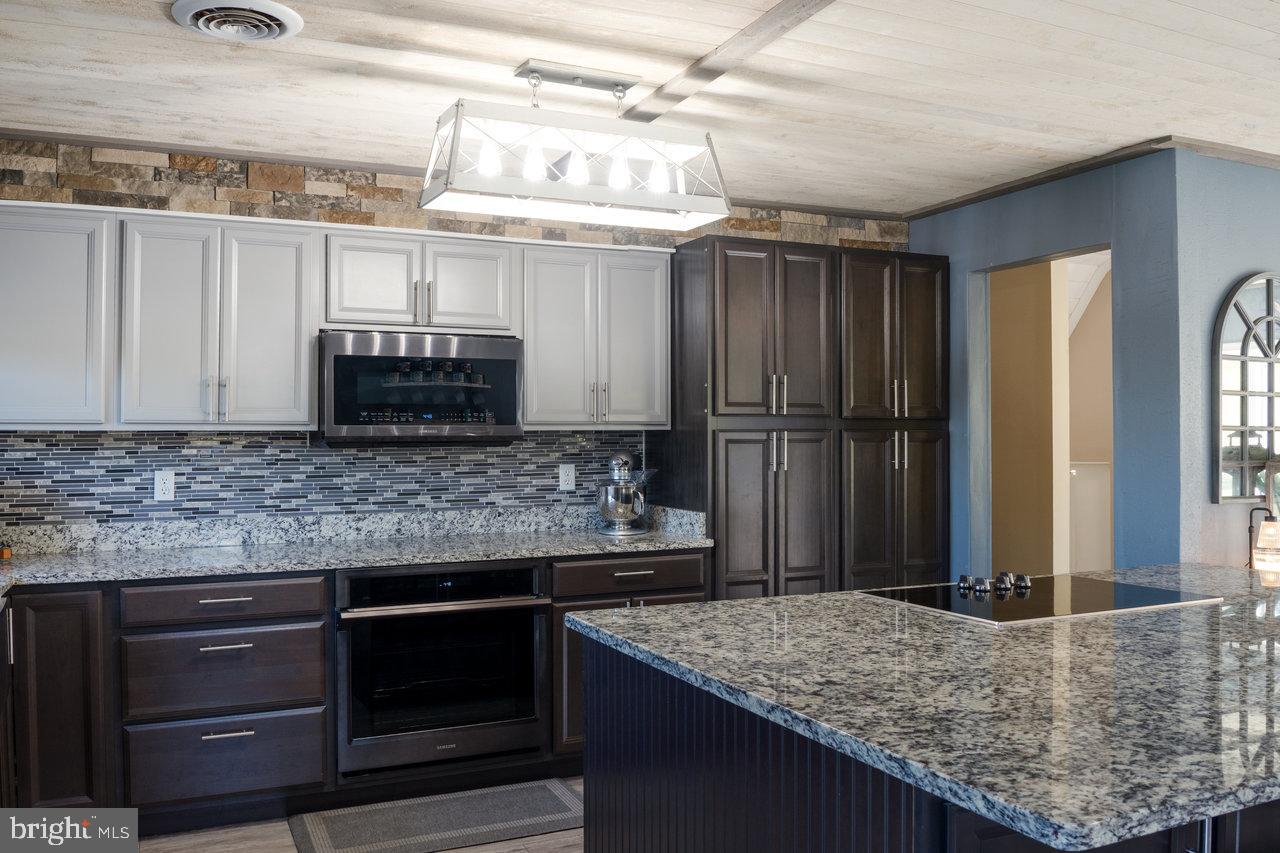 212 Whitacre Road Gore, VA 22637 - Photo 14 of 100 a kitchen with kitchen island granite countertop a sink stove and refrigerator