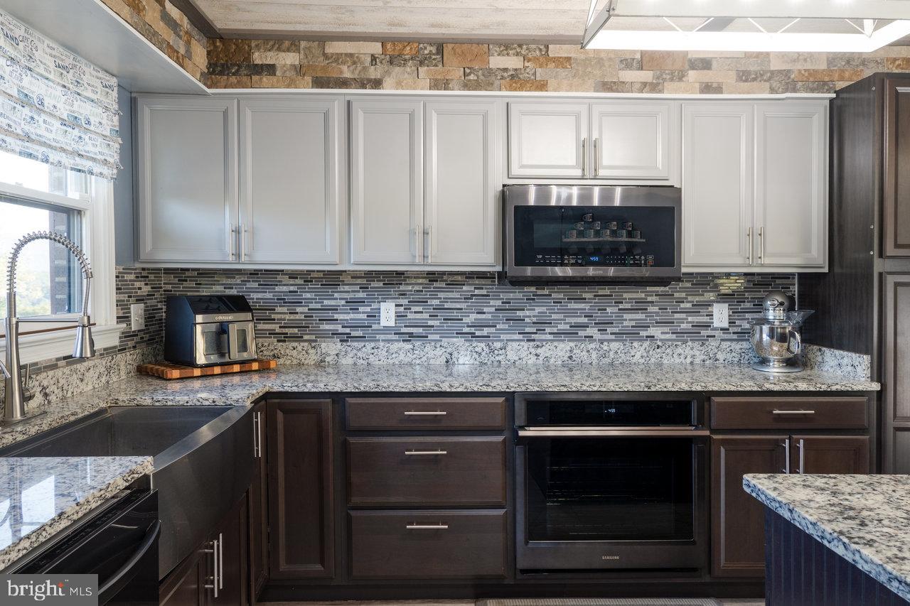 212 Whitacre Road Gore, VA 22637 - Photo 20 of 100 a kitchen with granite countertop a stove sink and cabinets
