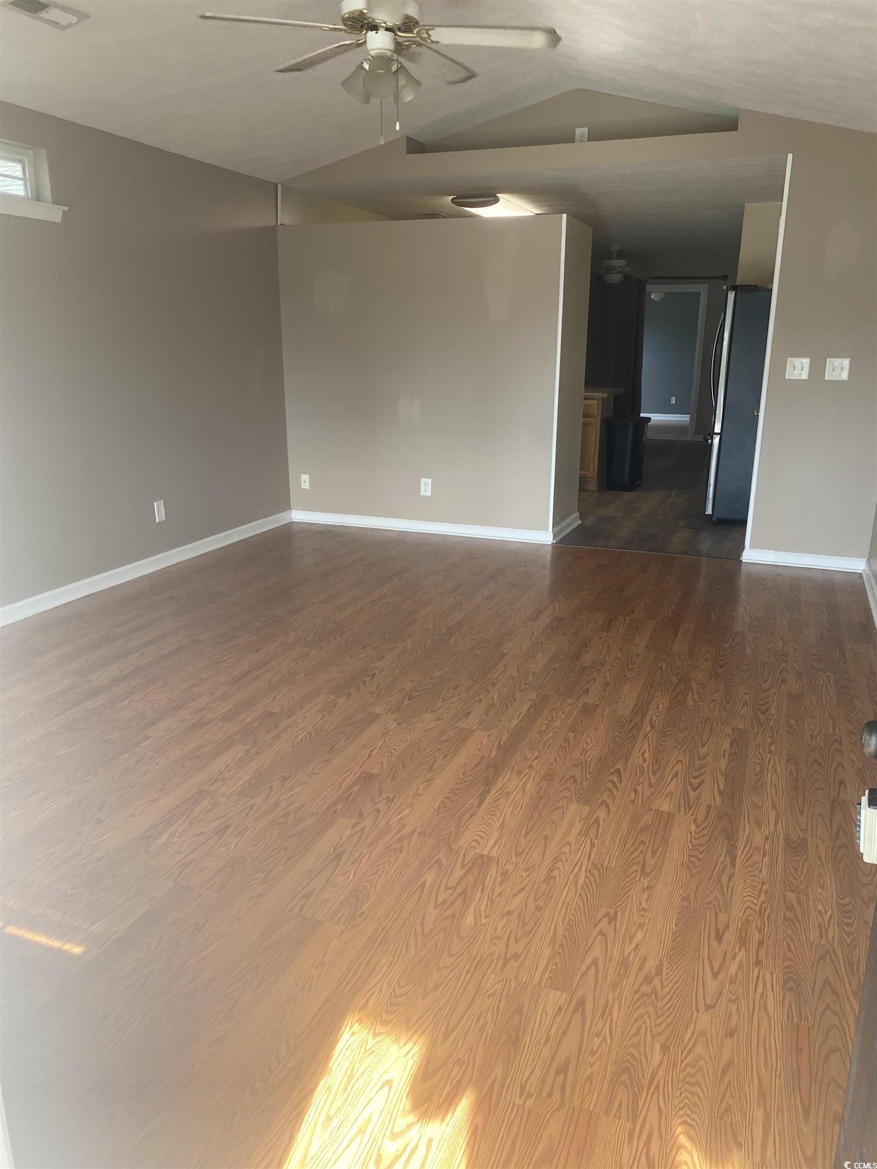9804 Conifer Lane Murrells Inlet, SC 29576 - Photo 8 of 14 Empty room with hardwood / wood-style floors, vaul