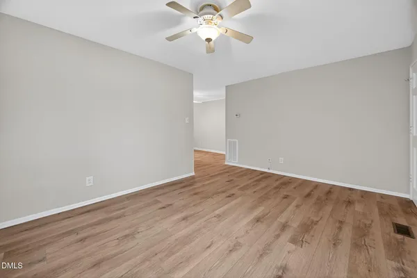 a view of a room with wooden floor and a ceiling fan