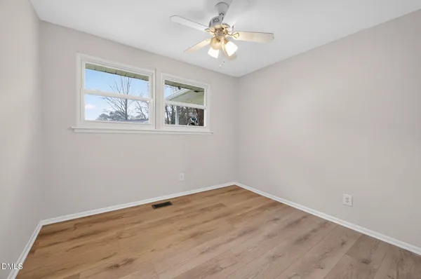 a view of empty room with wooden floor