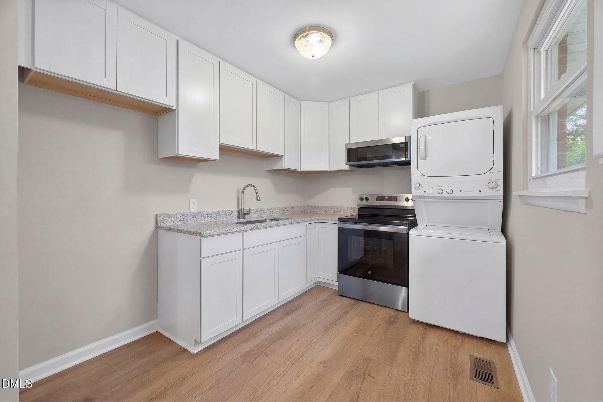 765 Bunche Drive Raleigh, NC 27610 - Photo 22 of 24 a kitchen with granite countertop white cabinets and white appliances
