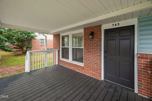 a view of backyard with deck and floor to ceiling window