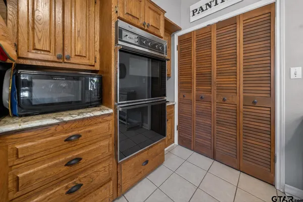 a kitchen with granite countertop white cabinets and stainless steel appliances
