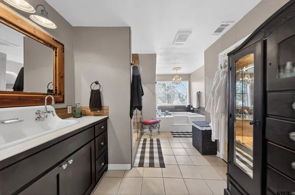 a bathroom with a double vanity sink a toilet a mirror and shower