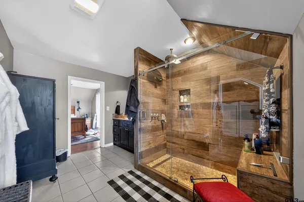 a bathroom with a glass shower door a sink and a mirror