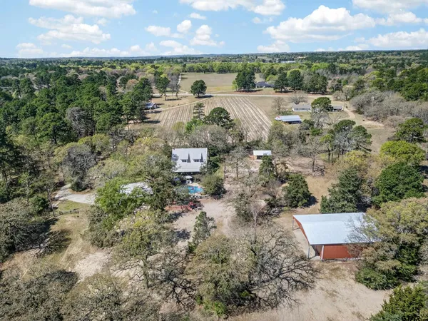 an aerial view of a house with a yard and lake view