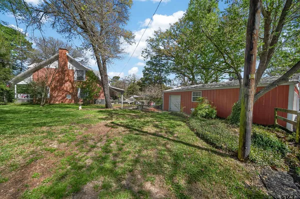 a view of a house with backyard and trees