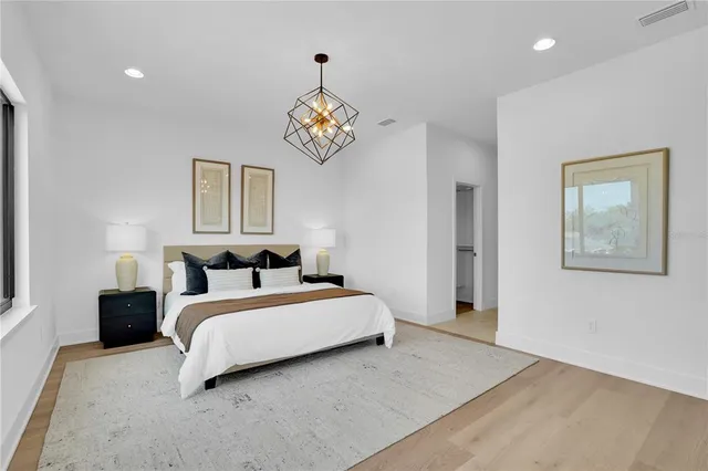 a spacious bedroom with a bed and painting on the wall