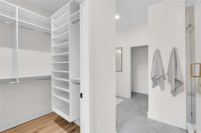 a view of walk in closet with empty racks