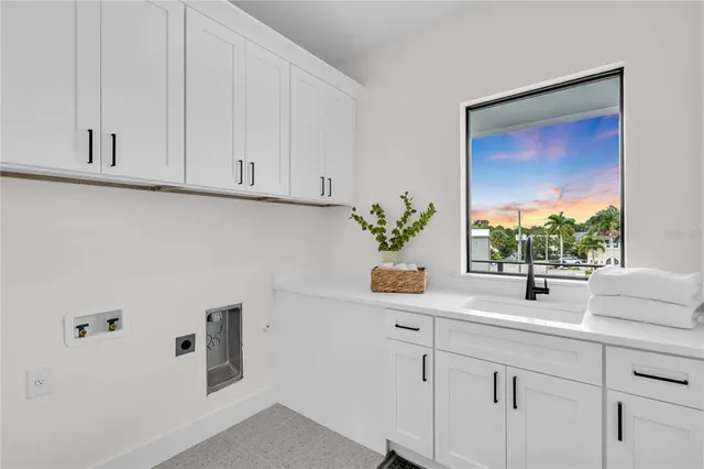 a kitchen with white cabinets and window