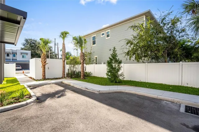 a front view of a house with a garden and parking