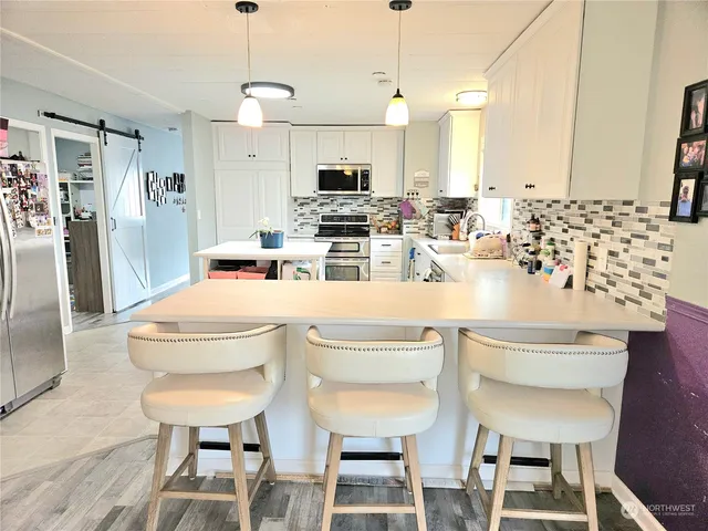 a kitchen with a dining table chairs sink and microwave