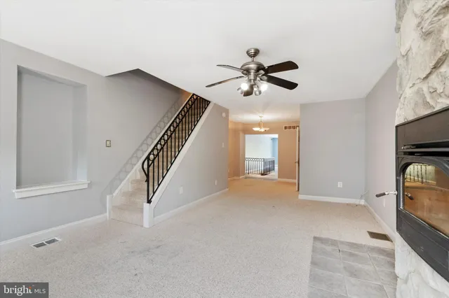 a view of an empty room with a fireplace and a window