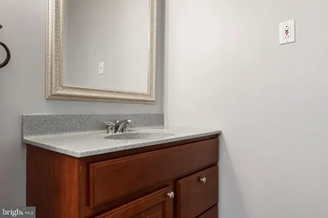 a bathroom with a granite countertop sink and a mirror