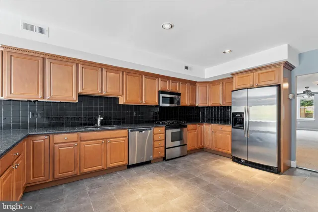 a kitchen with stainless steel appliances granite countertop a refrigerator and a sink