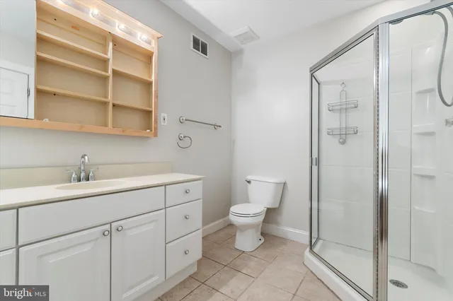 a bathroom with a toilet sink a shower and vanity