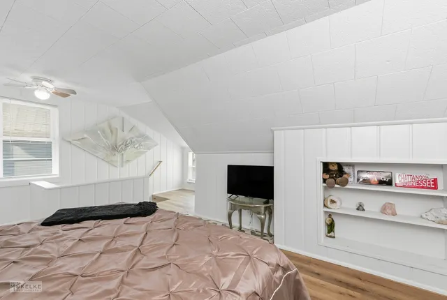 a bedroom with a bed and a flat screen tv