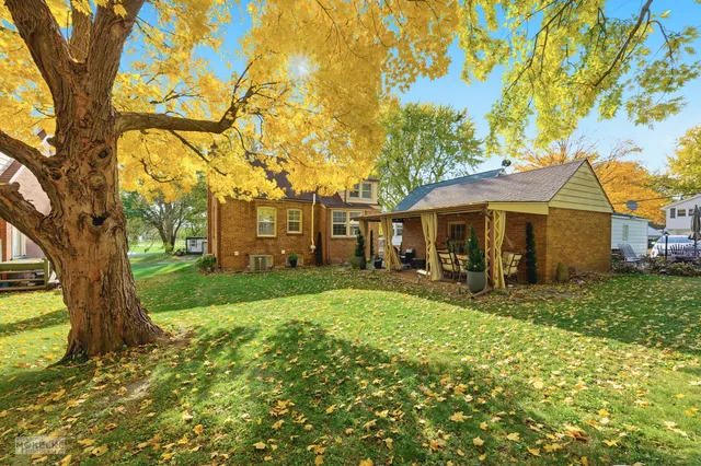 a view of a house with backyard and a tree