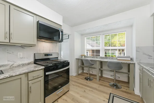 a kitchen with a stove a sink and a microwave